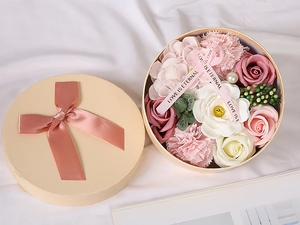 Overhead view of a round gift box with soap roses, carnations, and Love Is Eternal ribbon