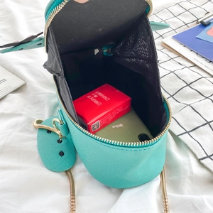 Close-up of mint green cross-grain leather bag interior with golden metal chain strap