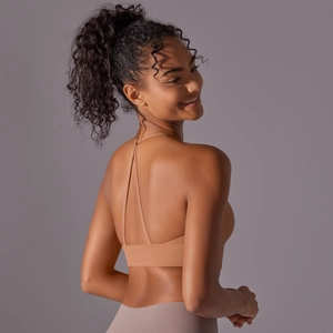 Detail of cross-back strap design on a seamless nude sports bra with elastic support