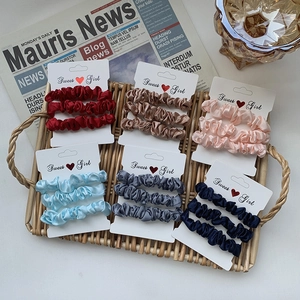 6-pack set of assorted satin scrunchies in colorful shades on bamboo display tray