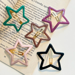 Colorful Y2K star hair clips in multiple shades displayed on a vintage book page