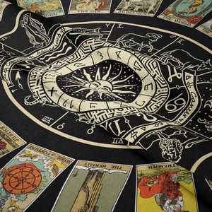 Detail of tarot tapestry fabric with gold zodiac symbols and The Sun tarot card pattern