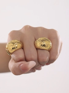 Detailed close-up of 18k gold plated chunky rings with heart texture on model's hand