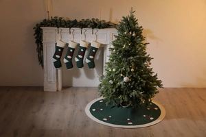 Détail du tapis de sapin de Noël vert tricoté et chaussettes assorties au motif bonnet Père Noël