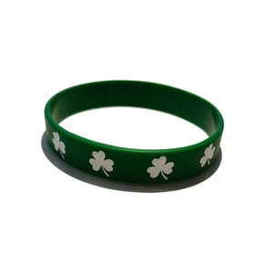 Detailed top view of a green St. Patrick's Day silicone wristband with white clover patterns