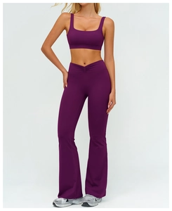 Dettaglio dei pantaloni da yoga a vita alta con fascia incrociata a V viola scuro