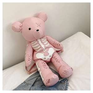Detail of pink bear-shaped leather backpack with white skeleton print and ribbon lacing