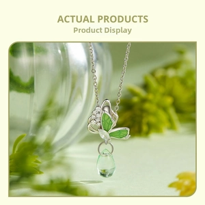 Detail of s925 silver butterfly charm with green enamel and emerald water drop pendant