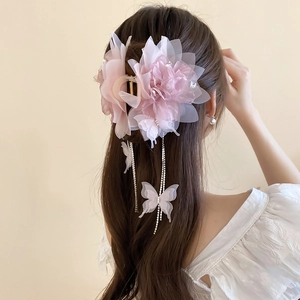 Dettaglio del mollettone rosa con fiore in rete, nappe a farfalla e catene di strass