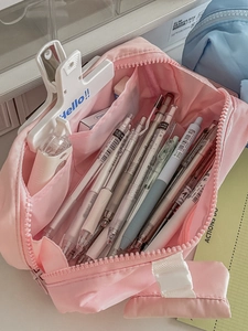 Detailed interior of the pink stationery pouch with organized dividers for pens and clips