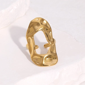 Irregular lava texture open ring in gold stainless steel shown on white natural stone