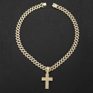 Close-up of gold iced-out cross pendant with cubic zirconia stones on Cuban link chain