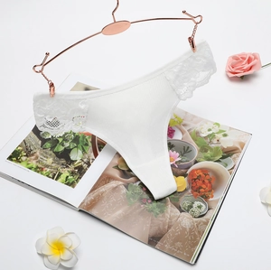 Elegant white lace thong for women with ribbed cotton fabric on a floral background