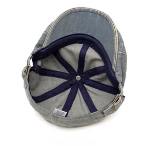 Detailed interior of denim flat cap showing blue reinforcing tape and size adjuster