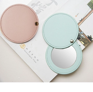 Detail of pink and blue PU leather mini makeup mirrors showing foldable design and stitching