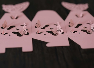 Detaillierte lasergeschnittene rosa Geschenkbox-Vorlage mit 3D-Schmetterling auf Holzgrund