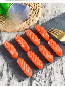 Vue détaillée de huit mini-saucisses en PVC avec marques de grill sur un plateau noir