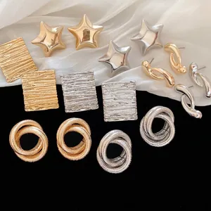 Modern knot and star earrings set in gold and silver finish with textured metal details