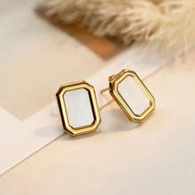 Macro view of minimalist rectangular gold earrings with white mother of pearl inlay