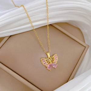Collier papillon élégant en titane doré avec cristaux roses sur de la soie blanche