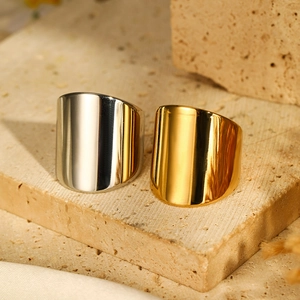 Macro shot of wide gold and silver stainless steel rings with high-polish mirror finish