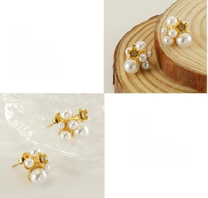 Detail of petal pearl earrings with gold finish and rhinestones on wooden background