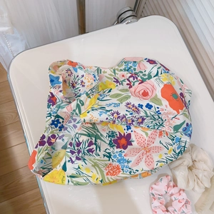 Flat lay of colorful floral cotton shoulder bag with vibrant red and yellow blooms