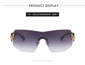Detail of gold butterfly hinge and gradient grey lenses on rimless oversized sunglasses