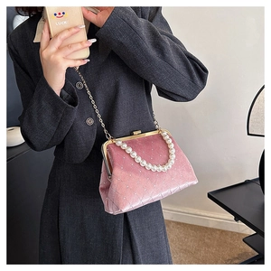 Detail of pink velvet shell bag with quilted texture and decorative pearl handle strap
