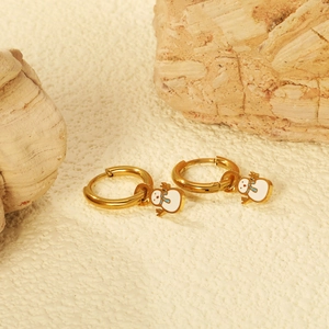 Minimalist gold hoop earring with cute white snowman charm on a textured stone background
