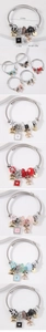 Detail view of heart and bear charms on stainless steel beaded bracelets with dimensions