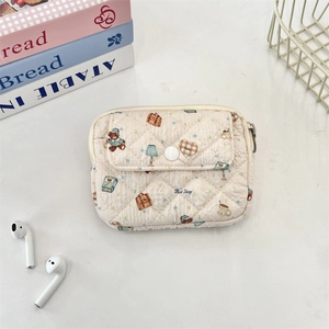 Macro detail of quilted cream storage pouch featuring cartoon bears and button pocket