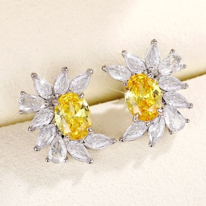 Macro detail of silver flower earrings with yellow oval zircon and clear teardrop gems