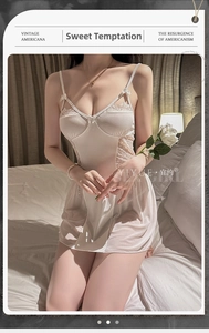 Detailed view of white satin sleepwear with delicate lace panels and bow accents