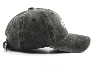 Detailed side view of washed black denim baseball cap with white letter embroidery