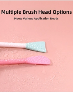 Close-up of dual-head silicone face brushes with soft bristles on a pink water-drop background