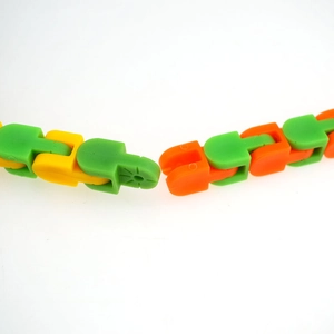 Close-up of interlocking green and orange plastic wacky tracks links for stress relief