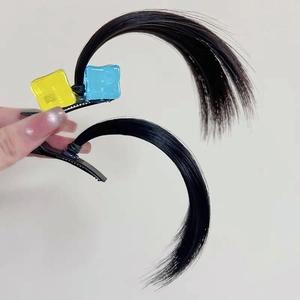 Close-up of hair clip props with synthetic strands and yellow blue square beads