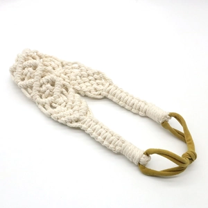 Close-up of bohemian handmade woven cotton headband with cream white textures