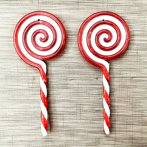 Detail view of red and white spiral acrylic lollipop ornaments for Christmas tree decor