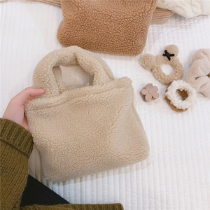 Détail d'un mini cabas en polaire beige avec texture pelucheuse douce et poignées