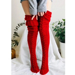 Thick red cable knit over-the-knee leg warmers in a soft indoor setting for autumn winter