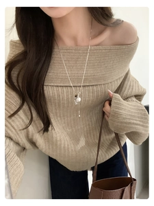Tiger eye and pearl pendant necklace styled with a beige off-shoulder knit sweater