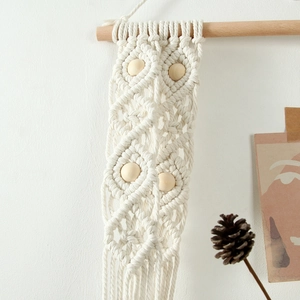 Close-up of macrame woven wall hanging featuring diamond patterns and wooden beads detail