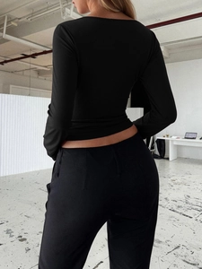 Close-up of the back view of a Y2K black lace long-sleeve top with elegant floral patterns