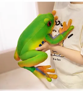 Close-up of oversized plush tree frog with red eyes being held to show soft texture