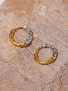 Detailed view of two-tone gold and silver earrings with hand-hammered metal texture