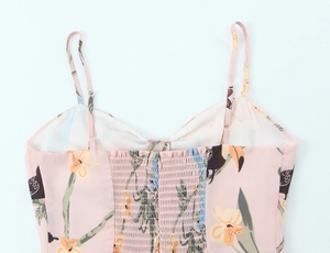 Détail des bretelles réglables et du smock élastique sur la robe rose à fleurs et oiseaux