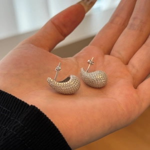 Elegant 925 sterling silver teardrop stud earrings with pave set zircon in hand display