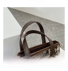 Détail de la texture pied-de-poule et de la poignée en cuir marron d'un sac à main chic